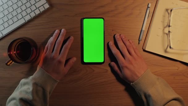 Man met mobiel met groen mockup scherm op het werk — Stockvideo