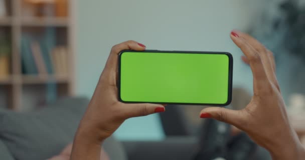 Afrika kökenli Amerikalı bir kadın cep telefonunun krom ekranını tıklatıyor. — Stok video