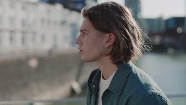 Chico guapo con corte de pelo de moda mirando a la cámara al aire libre — Vídeos de Stock