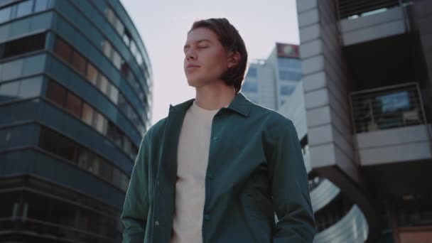 Young man in casual wear posing on street of big city — Stock Video