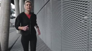 Fitness yetişkin kadın şehir caddesinde yalnız koşuyor