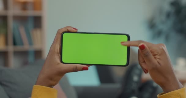 Mujer sosteniendo teléfono inteligente y desplazándose en la pantalla verde — Vídeos de Stock