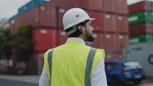 Vista posteriore dell'uomo in casco che cammina al porto del magazzino — Video Stock