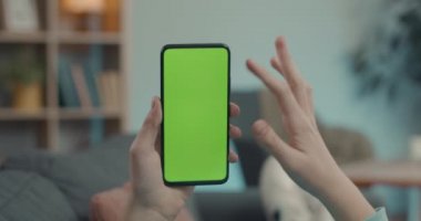 Adam yeşil ekranda akıllı telefondan jest yapıyor.