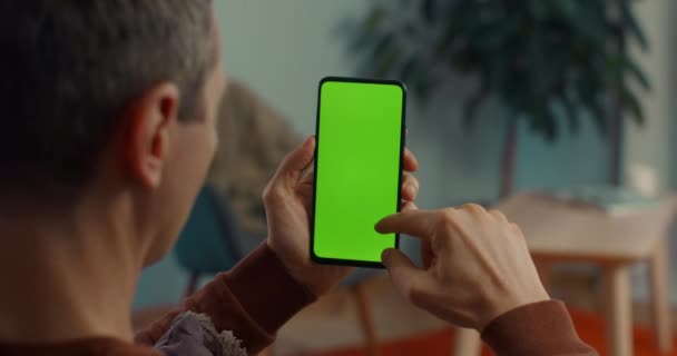 Blanke man scrollen op groen scherm van smartphone — Stockvideo