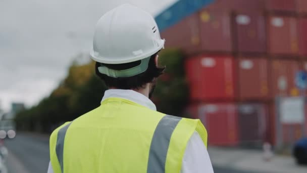 安全ヘルメットの男と貨物港に立つベスト — ストック動画