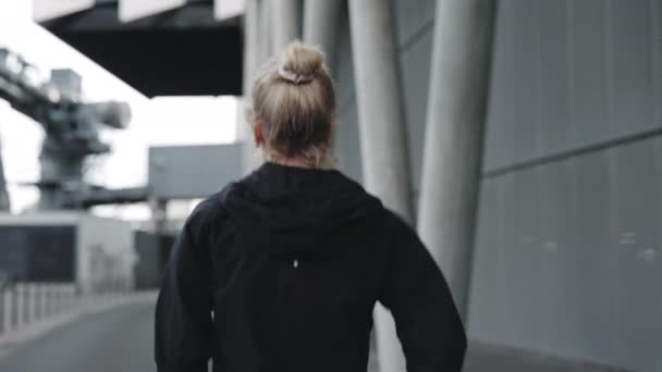 Вид ззаду зрілої жінки, що біжить по міській вулиці — стокове відео
