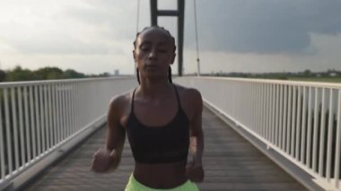 Kentsel alanda koşan sağlıklı Afro-Amerikan kadın.