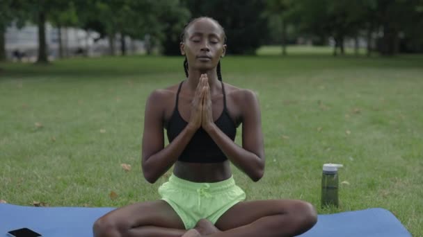 Vrouw mediterend met namaste gebaar in stadspark — Stockvideo