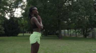 Afrikalı Amerikalı kadın Green Park 'ta meditasyon yapıyor.