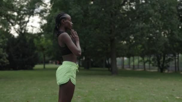 Afroamerikanerin meditiert allein im grünen Park — Stockvideo
