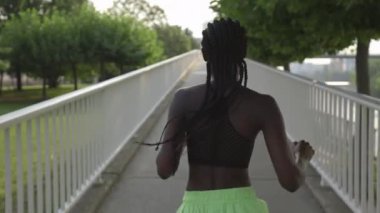 Köprüde örgü ören Afrikalı Amerikalı kadın.