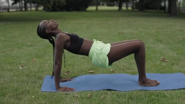 Mujer afroamericana haciendo ejercicios de yoga en el parque — Vídeos de Stock