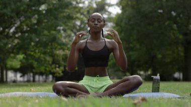 Meditasyon yaparken kameraya bakan Afrikalı Amerikalı kadın