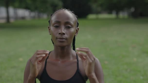 African american woman looking at camera while meditating — Stockvideo