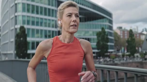 Reife Frauen in Kopfhörern genießen den Lauf im Freien — Stockvideo