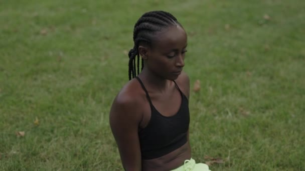 Женщина с косичками проводит время для занятий йогой в парке — стоковое видео