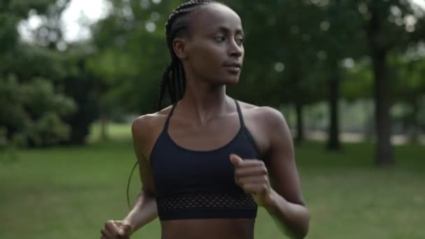 African american woman jogging at summer park — Stockvideo