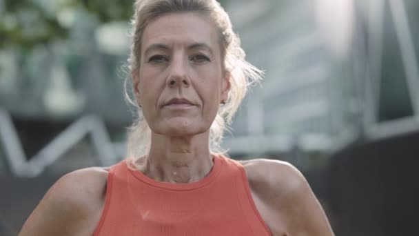Retrato de mujer mayor en ropa deportiva posando en la calle — Vídeos de Stock