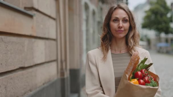 Kvinna gå utomhus och bära väska med mat — Stockvideo