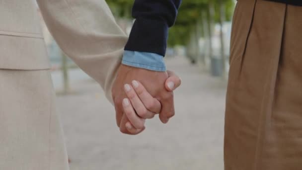 Close up of couple holding hands while walking outdoors — Video Stock