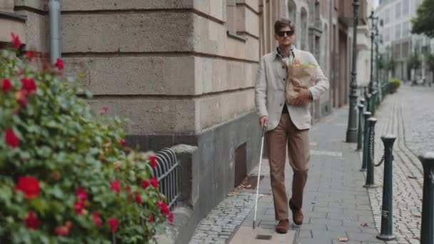 Hombre con discapacidad visual que lleva bolsa de comestibles en la calle — Vídeos de Stock