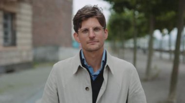 Şehir caddesinde duran gözlüklü adamın portresi.