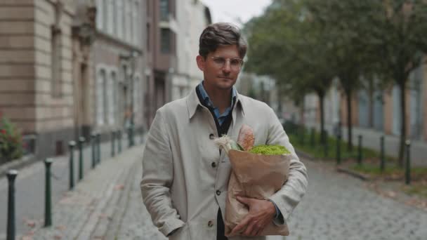 Empresario de pie en la calle y sosteniendo la bolsa de comestibles — Vídeos de Stock