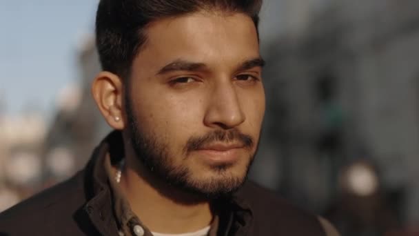Індійський чоловік стоїть на вулиці і посміхається на фотоапараті — стокове відео