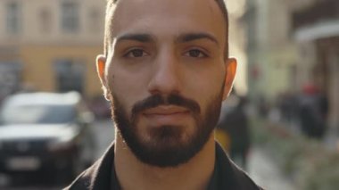 Close up portrait of confident muslim man posing on street
