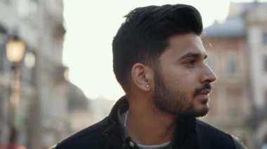 Indian guy standing outdoors and smiling on camera