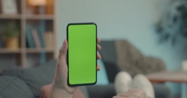 Close up of mobile phone with green screen in male hands
