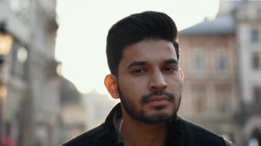 Muslim man standing on city street with calm face