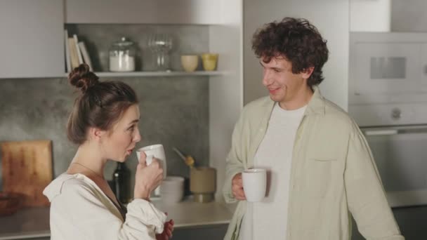 Муж и жена пьют кофе и разговаривают на кухне. — стоковое видео