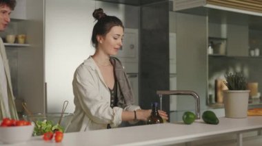 Wife and husband embracing and kissing on modern kitchen