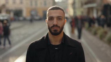 Handsome arabian man with calm face posing on city street