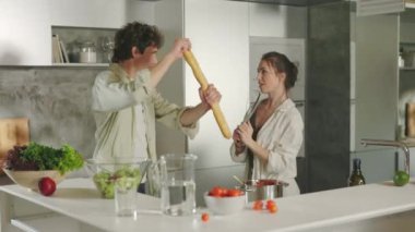 Two loving people having fun while cooking at home