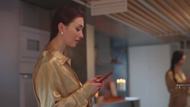 Vista laterale della donna utilizzando cellulare mentre in piedi sulla cucina — Video Stock