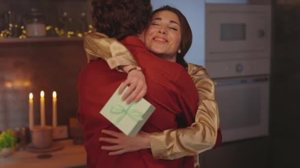 Žena s dárkovou krabicí objímající svého milujícího muže doma — Stock video