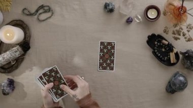 New York, ABD - 1 Mayıs 2021: Kadın çingene falcı müşterisi birini parmağıyla işaret ederken mum ışığında tarot kartlarını masaya koyuyor. Esrarengiz kavram.