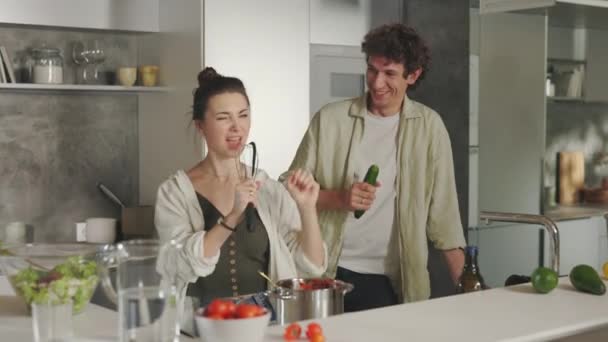 Para tańczy i śpiewa w kuchni podczas gotowania — Wideo stockowe