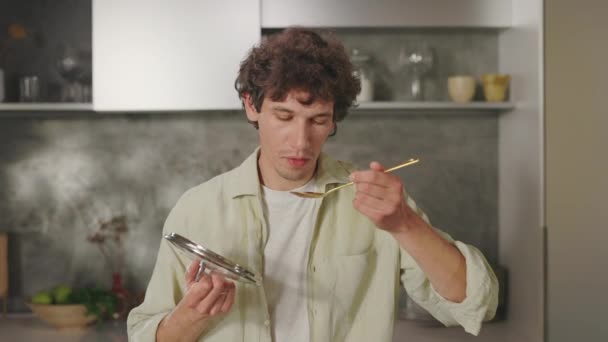 スプーンで食べながらおいしい食事を楽しむ男 — ストック動画