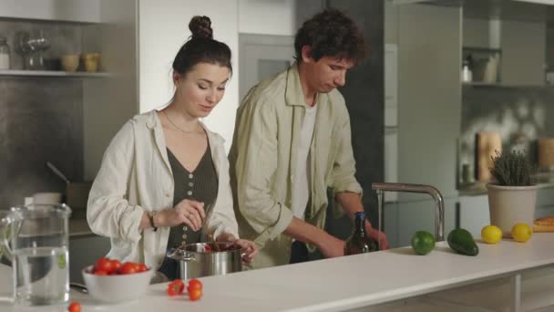Mutfakta kadınını pişiren domates sosu tatmış bir adam. — Stok video