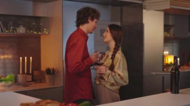 Birbirine aşık çiftler evlerinde flört ederken şarap içiyorlar.