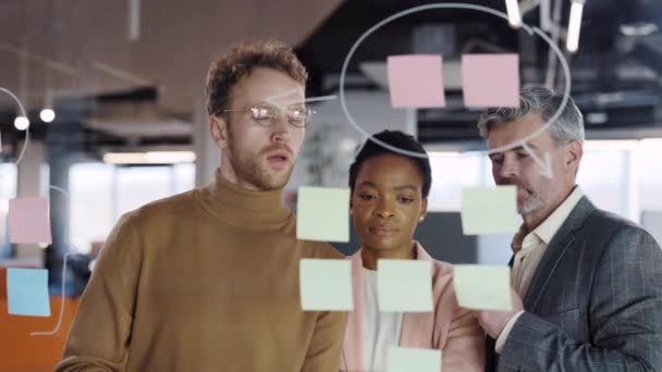 Junge kaufmännische Mitarbeiter beim Brainstorming neuer Projektlösungsstrategien auf Glasplatten. Afrikanisch-amerikanische Teamleiterin zeigt Problemlösung in Bürokonferenz. Konzept der Teamarbeit. — Stockvideo