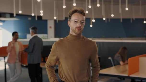 Úspěšný mladý muž ve formálním obleku otáčí hlavu a dívá se do kamery, zatímco stojí na kancelářské budově. Vousatý běloch pózující v kancelářském centru — Stock video