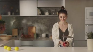 Mutfaktaki kadına iki poşet getiren adam.