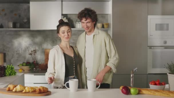 Para całujących się, obejmująca i pijących kawę w kuchni — Wideo stockowe