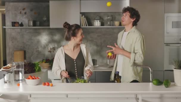 Veselý pár vaření večeře společně v kuchyni — Stock video