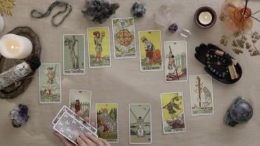New York, ABD - 1 Mayıs 2021: Tarot okuyucusu kart dağıtıyor ve geleceği ve serveti okuyor. Kadın ellerinin yukarıdaki görüntüsü tahmin yaparken kartları masanın üstüne koyuyor. Kahin kavramı.